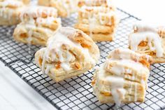 several pastries on a cooling rack with icing drizzled over them