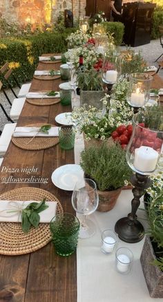 a long table is set with place settings and flowers