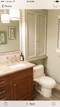 a white toilet sitting next to a sink in a bathroom under a window with blinds