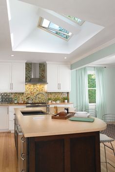 a kitchen with an island and skylight above it