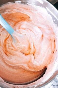 a mixing bowl filled with whipped cream on top of a counter