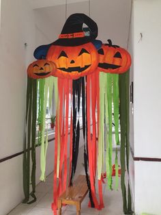 an entrance decorated for halloween with pumpkins and green streamers hanging from the ceiling