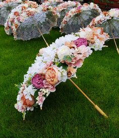 several umbrellas with flowers on them sitting in the grass