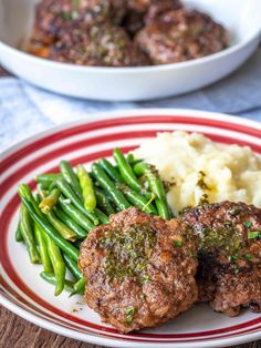 meatballs, green beans and mashed potatoes on a red and white striped plate