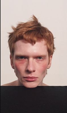 a man with red hair is looking at the camera