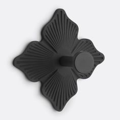 a black flower shaped object on a white surface