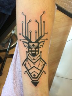 a tattoo on the arm of a person with a deer head and geometric shapes in black ink