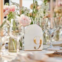 the table is set with flowers, candles and wine glasses for an elegant wedding reception