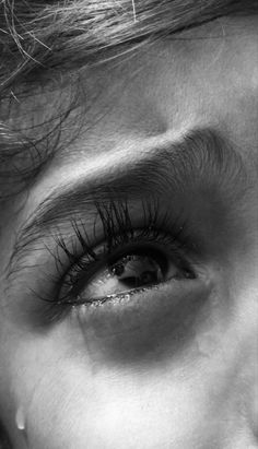 black and white photo of woman's eye with long lashes looking at the camera