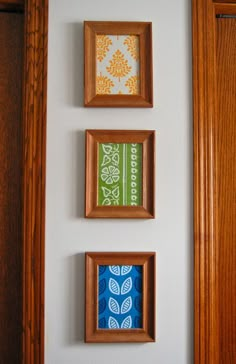 three wooden frames are hanging on the wall