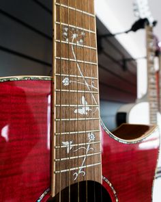 an acoustic guitar is sitting on display in a room with other musical instruments behind it