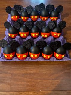 there are many mickey mouse cupcakes on the table with their faces painted orange and black