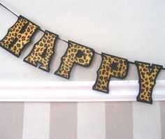 an animal print happy birthday banner hanging on a wall