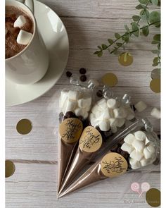 three bags filled with marshmallows next to a cup of coffee and gold confetti