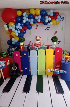 a birthday party with musical instruments, balloons and streamers on the piano keyboard as decoration