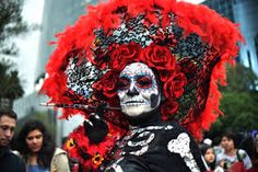 a woman with red hair and makeup is dressed up in skeleton costume for the day of the dead parade