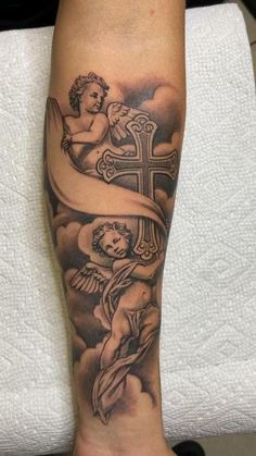 a person with a cross and angel tattoo on their leg