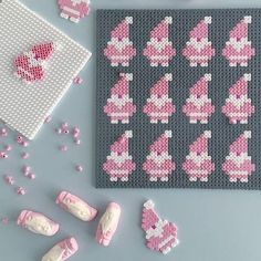 pink and white items displayed on grey surface next to gray mat with cross stitch pattern