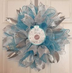 a blue and silver mesh wreath on a door with the words be your own bright