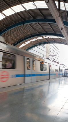 a train is coming down the tracks in an empty station with no people on it