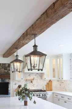 a kitchen with two lights hanging from the ceiling and a potted plant on the counter