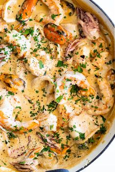 a skillet filled with chicken and shrimp covered in gravy, garnished with parsley