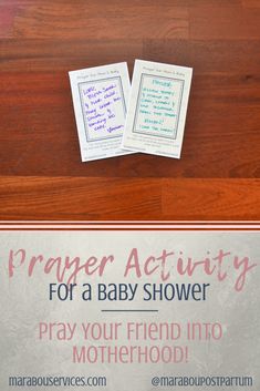 two baby shower cards sitting on top of a wooden table