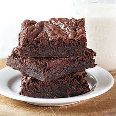 three brownies stacked on top of each other in front of a bottle of milk