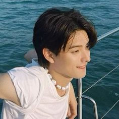 a man in white shirt sitting on top of a boat