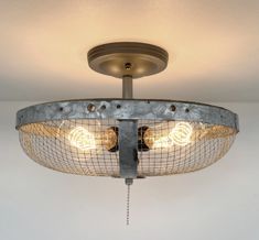 a light that is hanging from the ceiling with some wire around it and two lights on each side