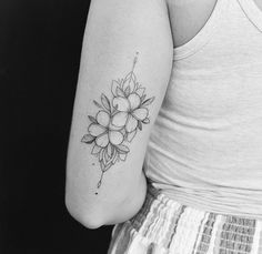 a black and white photo of a woman's arm with a flower tattoo on it