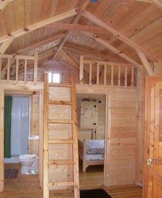 the inside of a wooden cabin with stairs leading up to it's loft area