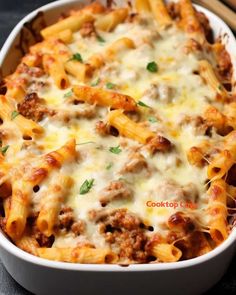 a casserole dish with meat and cheese in it on a black countertop