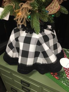 a christmas tree with a black and white checkered skirt on it's top