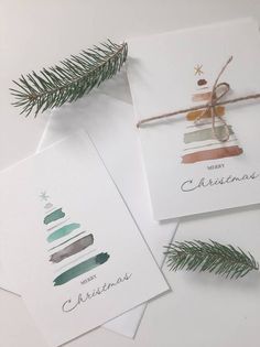 three christmas cards with watercolor trees on them