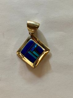 This beautifully well crafted Square Pendant has been handmade by a Navajo Artisan. The Colors of the Pendant come from Lapis Lazuli, Turquoise and Blue Opal. It is stamped Sterling and signed by the Artist. The Pendant measures 1.75” long and over 1.25” wide. There are two pendants available and the design will vary. “Winds of Wisdom” (Lapis Lazuli, Turquoise and Blue Opal. The Navajo (Dine’) believe that the wind is a powerful source. The native tradition believes that at any moment, the blowi Artisan Blue Jewelry With Inlay, Traditional Blue Inlay Jewelry, Traditional Blue Jewelry With Inlay, Blue Bohemian Jewelry With Inlay, Artisan Blue Rectangular Jewelry, Square Pendant, Blue Opal, Turquoise Blue, The Wind