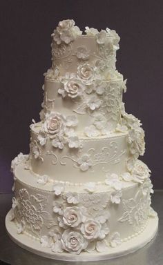 a three tiered wedding cake with white frosting flowers on the bottom and sides