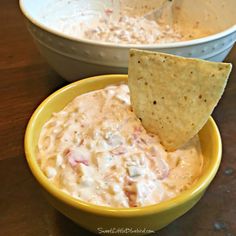 a yellow bowl filled with dip and a tortilla chip