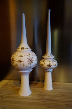 two white vases sitting on top of a wooden table