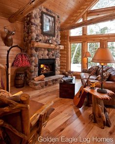 a living room filled with furniture and a fire place in front of a stone fireplace