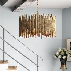 a chandelier hanging from the ceiling in a room with white walls and flowers