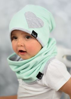 a baby wearing a green hat and scarf