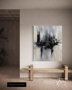 an abstract painting hangs on the wall above a wooden bench