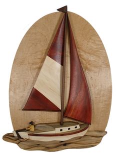 a wooden sailboat on a piece of wood