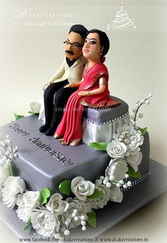 a cake with a couple sitting on top of it