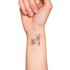 a woman's arm with a small bird and flower tattoo on the left wrist