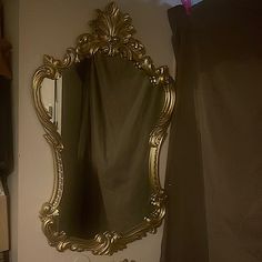 a bathroom with a sink, mirror and shower curtained in gold leafy design