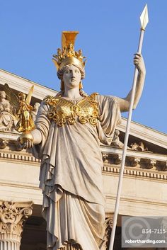 the statue of lady justice is holding a spear in front of an ornate building with columns