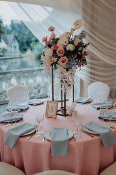 the table is set with plates, silverware and flowers