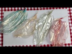 three pieces of foil sitting on top of a red and white checkered table cloth